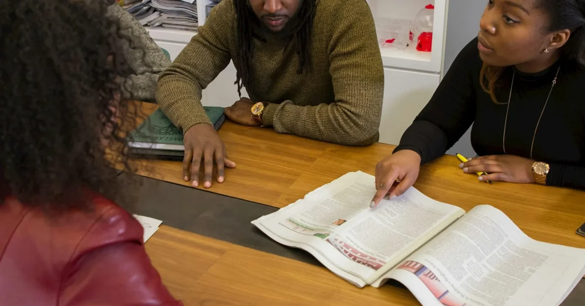 Coworkers discussing a problem at a table using conflict resolution skills to resolve workplace disagreement